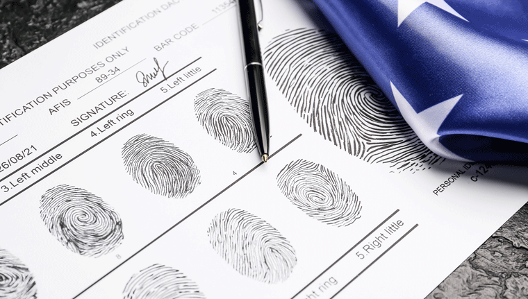 Fingerprints on a piece of paper with a pen and American flag