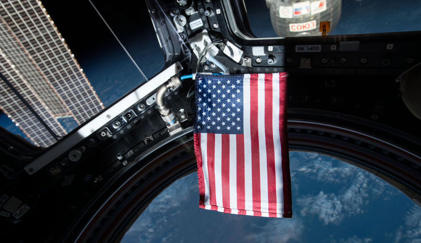 U.S. flag in the Cupola window of the International Space Station