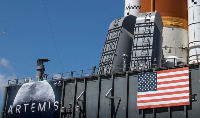 Close-up of the platform supporting NASA's Space Launch System. The platform has a large Artemis poster and an American flag.