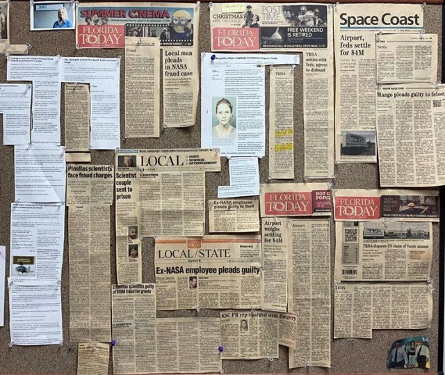 A cork board of newspaper clippings containing headlines about NASA investigations