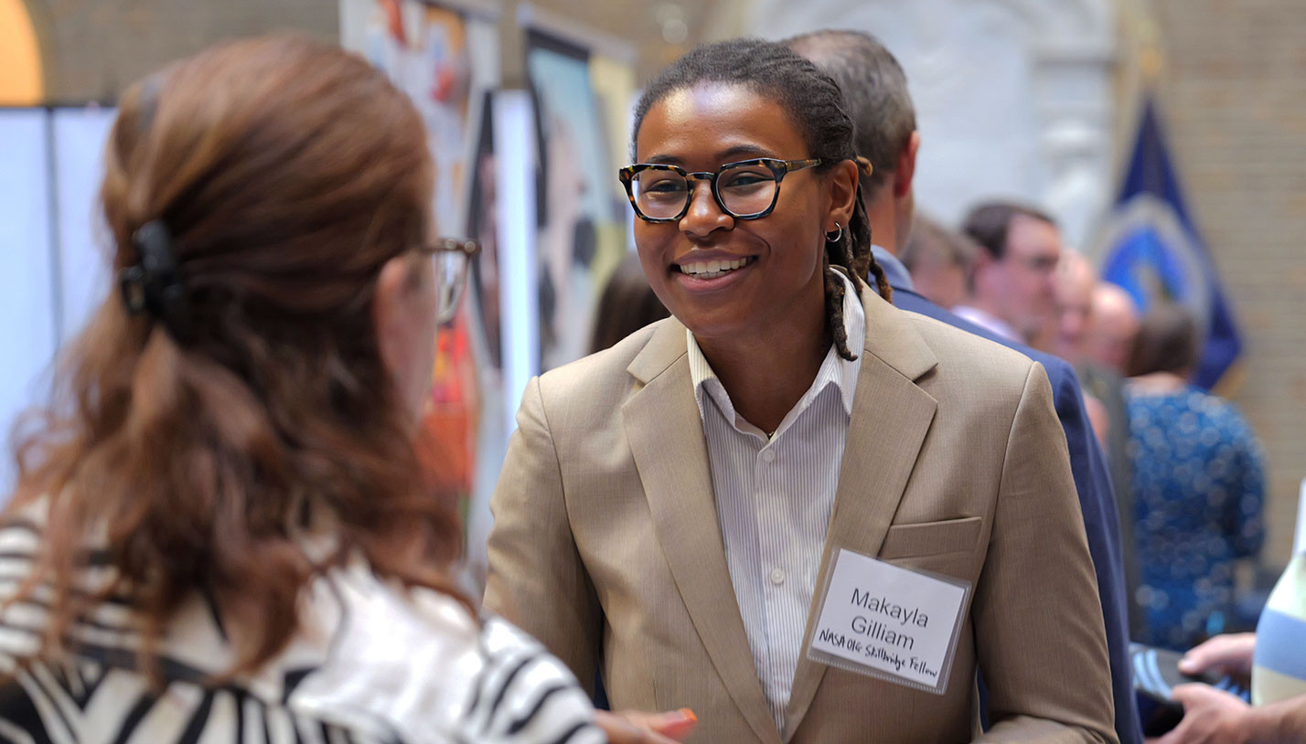 Makayla Gilliam smiling and speaking to an attendee at a career fair