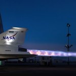 Close-up of the back of the X-59 supersonic aircraft at night with glowing exhaust shooting out the back.