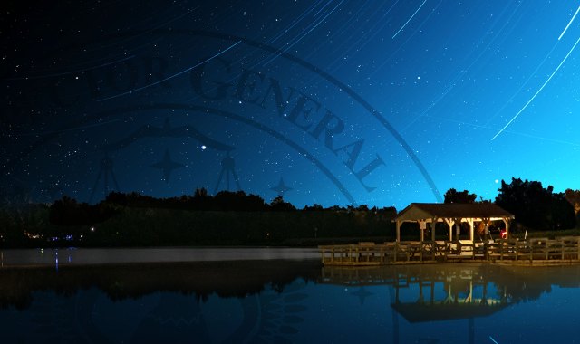 Night sky with stars over a lake with a small dock.