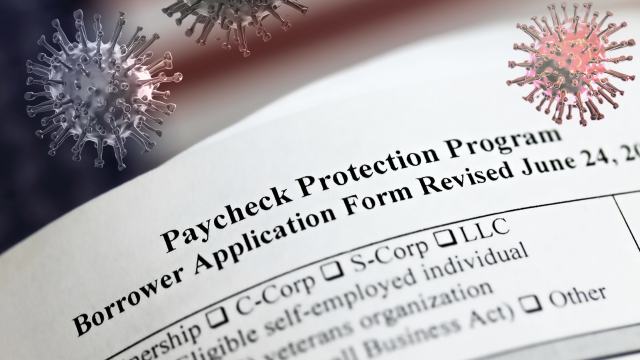 A blank Paycheck Protection Program application with illustrations of COVID-19 particles