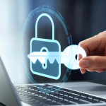 A lock hovering above a laptop, with a hand holding a key and placing it into the lock.
