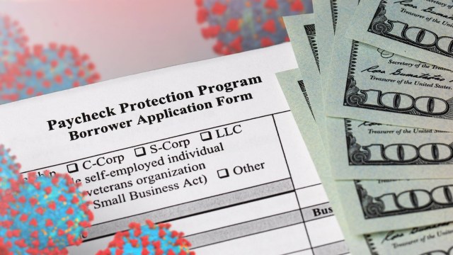 A Paycheck Protection Program application with a stack of $100 bills and illustrations of COVID-19 particles