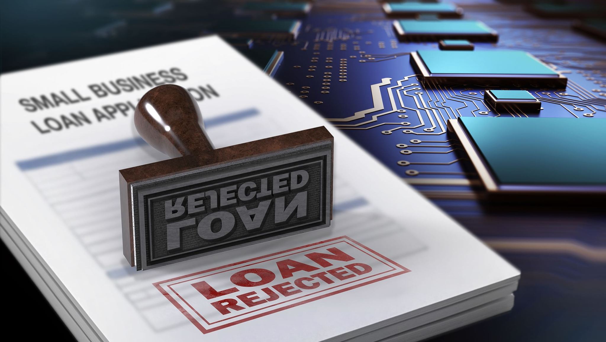A small business loan application form with a "loan rejected" stamp. An enlarged computer circuit board is in the background.